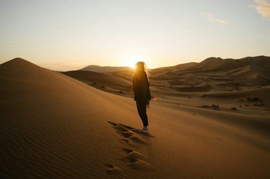 Mujer con chaqueta caminando en el desierto